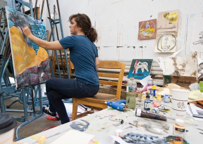 A student works on an acrylic painting in the Advanced Drawing class.