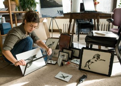 Student Michelle Bridwell prepares artwork to be displayed during a student art sale.