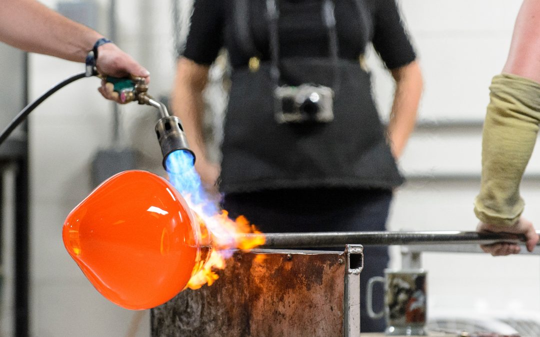 Students inflate Madisons largest glass ornament during a UW Glass Lab event in the Art Lofts Building at the University of Wisconsin-Madison. The public event featured students from the UW Mad Gaffer team performing a number of interesting glass experiments and working together to create a giant Christmas ornament that was auctioned off for charity.