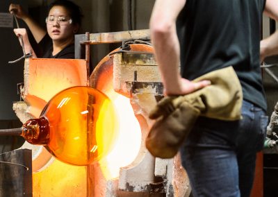 Students remove Madison's largest glass ornament from a gas furnace during a UW Glass Lab event in the Art Lofts Building at the University of Wisconsin-Madison. The public event featured students performing a number of interesting glass experiments and working together to create a giant Christmas ornament that was auctioned off for charity.