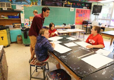 An art education student practices hands-on learning teaching a youth art class. Art education students experience a four semester sequence of classes introducing students to the teaching profession, including child development, learning theories, inclusive schooling strategies, curriculum and instruction, history of American education, and rigorous Art Education methods courses, plus 200 hours of practicum and 18 weeks of student teaching.