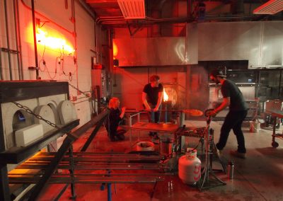 Students work together to inflate a glass piece at the UW Glass Lab in the Art Lofts Building at the University of Wisconsin-Madison.