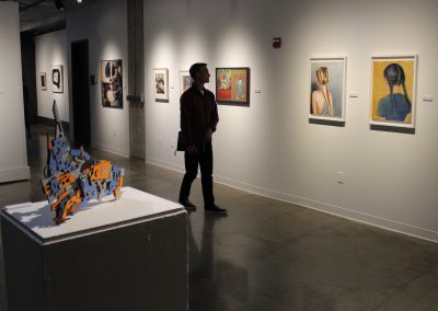 A visitor views the University of Wisconsin-Madison graduate student work on display at the Swap Meet trade show with the University of Minnesota-Twin Cities.