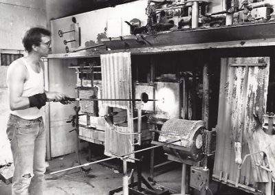 In the glass lab a student uses the furnace to soften glass.