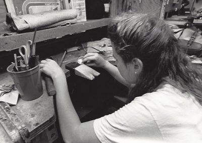 A student crafts an art metal piece.