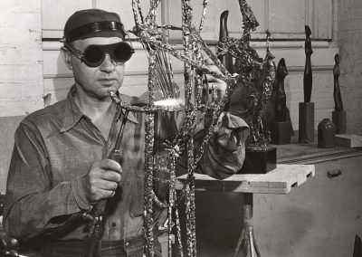 In July of 1953, Professor Humbert Albrizio, of the art education department, uses a blowtorch to weld a piece of sculpture.