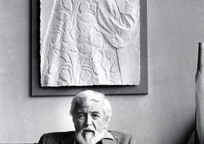 Dean J Meeker, professor of art, sitting at the desk in his office, ca. 1985. Meeker taught at the University from 1946 to 1992.