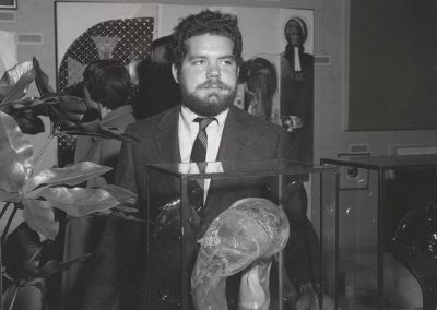 Dale Chihuly stands behind his art glass sculpture at the Memorial Union Art Salon exhibition, ca. 1966. In 1967, Chihuly received a Master of Science degree in sculpture, and in 2013 the University awarded him an Honorary Doctorate of Fine Arts.