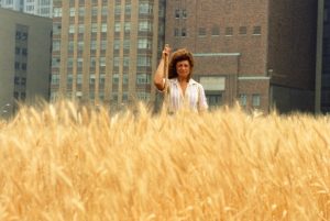 Wheatfield – A Confrontation: Battery Park Landfill, Downtown Manhattan – With Artist in the field, 1982, by Agnes Denes